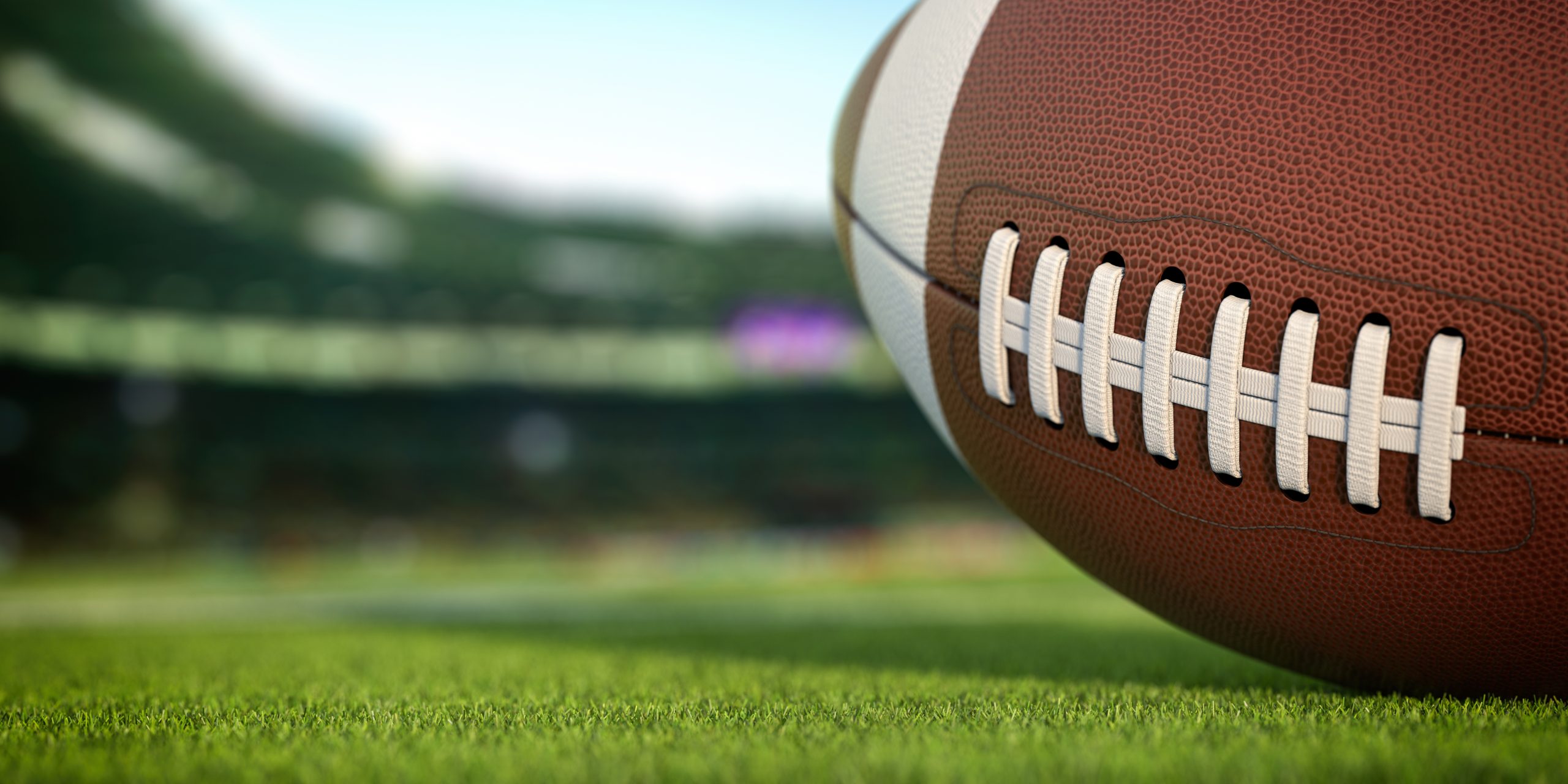 american-football-ball-on-grass-of-football-arena-2021-09-02-02-44-09-utc-scaled.jpg